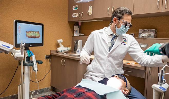 Dentist grabbing a dental instrument while treating a patient