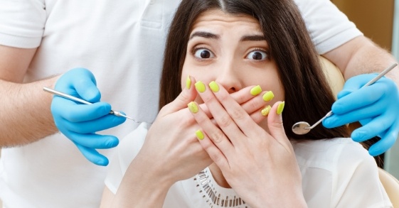 Dental patient covering her mouth with her hands