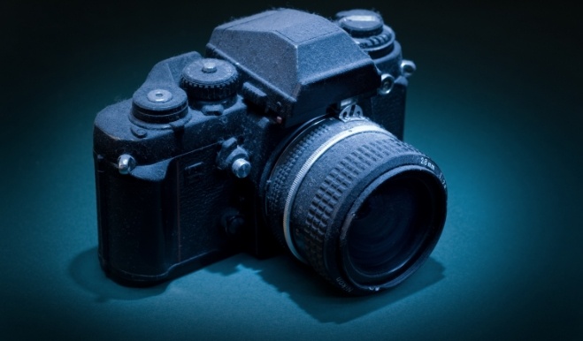 Black camera against dark blue background