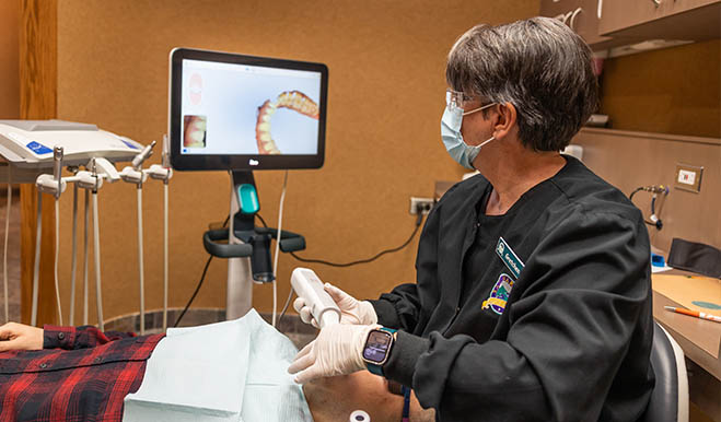 Dental team member taking photos of a patients teeth using scanner