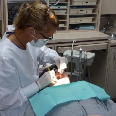Dentist wearing dental binoculars while treating a patient