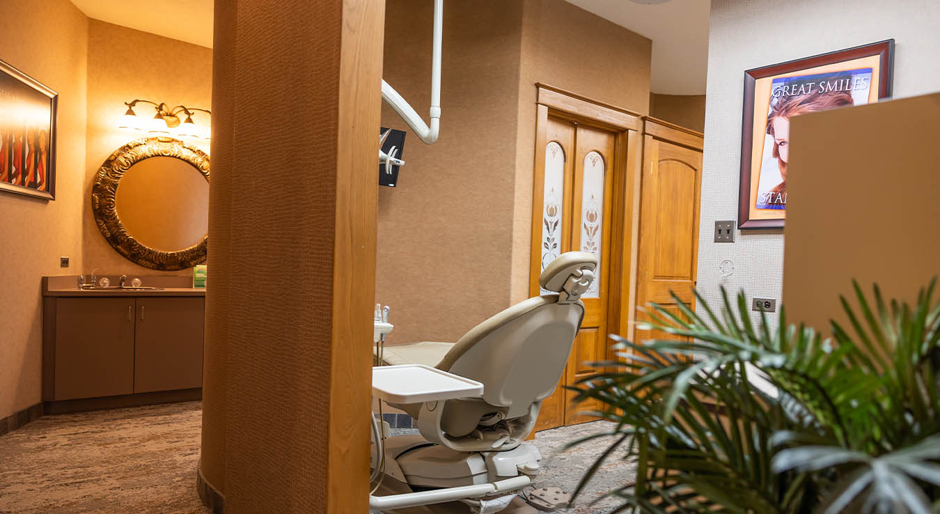 Dental treatment chair with wall mirror and hallway in background