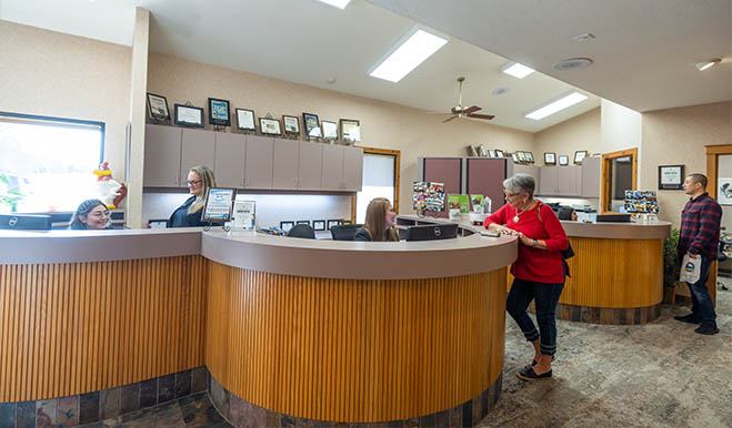 Senior woman talking to receptionist in San Marcos dental office