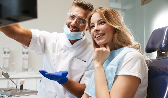 Patient reviewing information on screen with smiling dentist