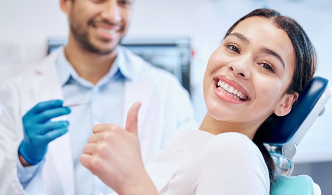 Smiling patient giving thumbs up in treatment chair