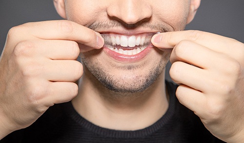 Man using teeth whitening strips