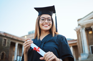 Female graduate smiling while holding her diploma
